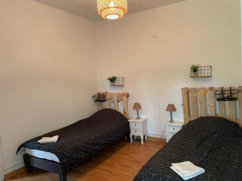 2 camas en una habitación con 2 mesas y lámparas en Gîte du Château d'Esnes, 