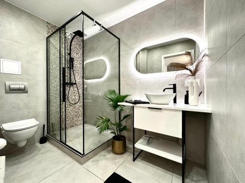 La salle de bains est pourvue d'une douche, de toilettes et d'un lavabo. dans l'établissement Moonlight Apartment ~ Self Check-In 24 ~ Parking & Lift, à Wrocław