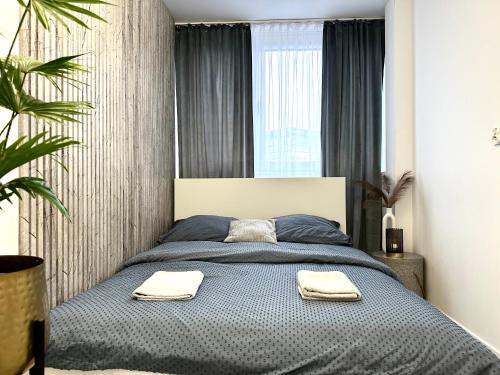 - une chambre avec un lit et 2 serviettes dans l'établissement Moonlight Apartment ~ Self Check-In 24 ~ Parking & Lift, à Wrocław