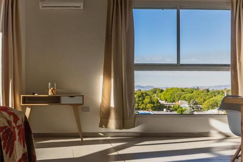 a bedroom with a large window with a view of a town at Superior Nevado Penthouse San Rafael in San Rafael