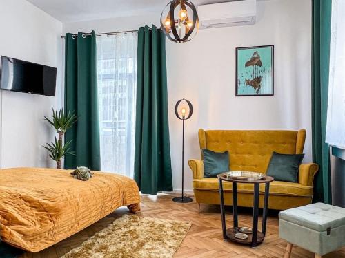 a bedroom with a yellow bed and a couch at Art deco studio in Old town in Bratislava