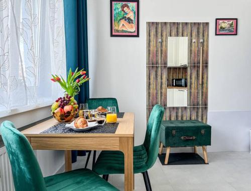 une salle à manger avec une table et des chaises vertes dans l'établissement Art deco studio in Old town, à Bratislava