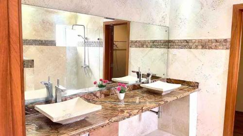 un bagno con due lavandini e un grande specchio di VILLA I-31 capacidad para 20 personas a Paraíso