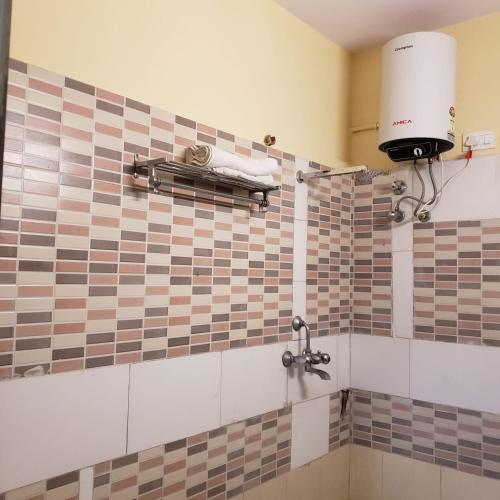 a bathroom with a tiled wall with a water fountain at Ever green guest house in Jaipur