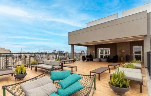 a patio with couches and chairs on a building at Lofts | Consolação | 3 min Metrô in Sao Paulo