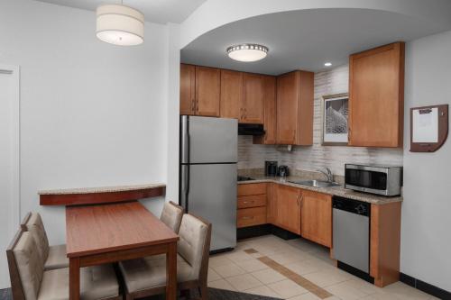 a kitchen with a wooden table and a refrigerator at Residence Inn East Rutherford Meadowlands in East Rutherford