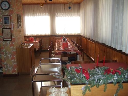 a dining room with tables and chairs with christmas decorations at Albergo Trieste in Tambre dʼAlpago