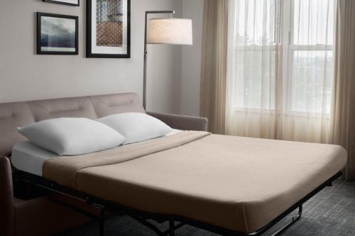 a bed with white pillows in a room with a window at Residence Inn East Rutherford Meadowlands in East Rutherford