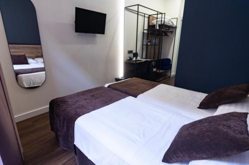 a hotel room with two beds and a mirror at Hotel BH San Francisco Alicante in Alicante