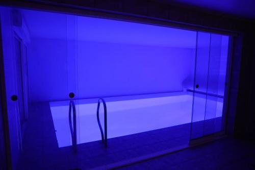 a dark room with a blue light in a room at Villa avec piscine intérieure in Holtzheim