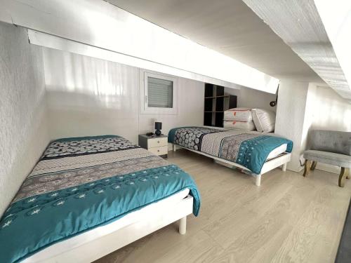 une chambre avec deux lits et une chaise dans l'établissement T2 avec Climatisation, Piscine, Box Privé - FR-1-702-6, au Cap d'Agde