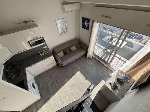 - un salon avec un canapé dans l'établissement T2 avec Climatisation, Piscine, Box Privé - FR-1-702-6, au Cap d'Agde