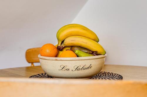a bowl of fruit with bananas and oranges on a table at Gamul Place - Quiet City Centre in Chester