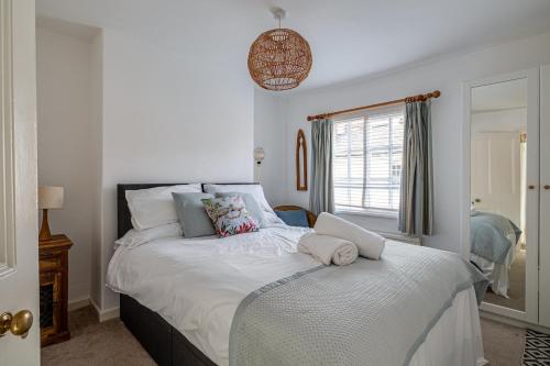 a bedroom with a bed with white sheets and a window at Gamul Place - Quiet City Centre in Chester