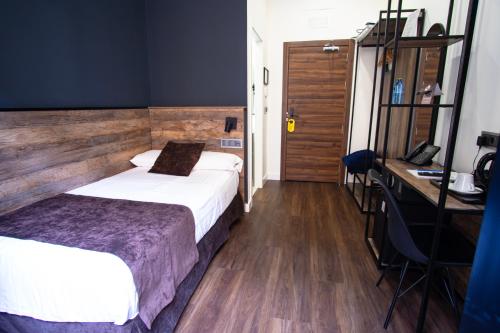 a hotel room with two beds and a desk and a desk at Hotel BH San Francisco Alicante in Alicante