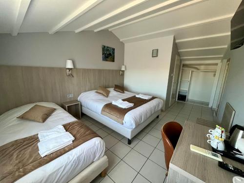 Ένα ή περισσότερα κρεβάτια σε δωμάτιο στο Hôtel Les Arcades