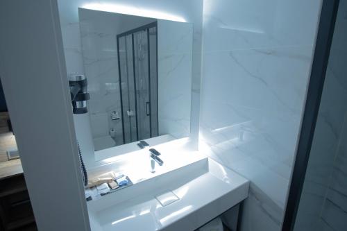 a white bathroom with a sink and a mirror at Hotel BH San Francisco Alicante in Alicante