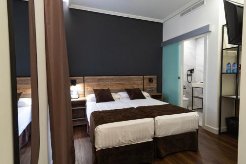 a bedroom with a large bed and a black wall at Hotel BH San Francisco Alicante in Alicante