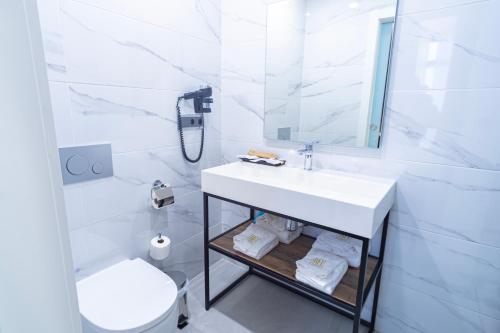 a white bathroom with a sink and a toilet at Hotel BH San Francisco Alicante in Alicante