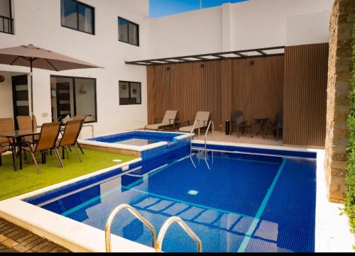 uma piscina com uma mesa e cadeiras e um guarda-sol em Hotel Bungalows Casa Blanca em Tenancingo de Degollado