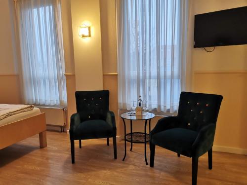 duas cadeiras e uma mesa num quarto de hotel em Hotel Deichvoigt em Cuxhaven