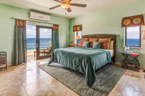 a bedroom with a bed with a view of the ocean at Anguilla Sunset Beach House in Crocus Hill