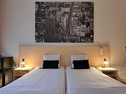 ein Schlafzimmer mit 2 Betten und einem Wandgemälde in der Unterkunft Hotel Restaurant Boven Groningen in Delfzijl