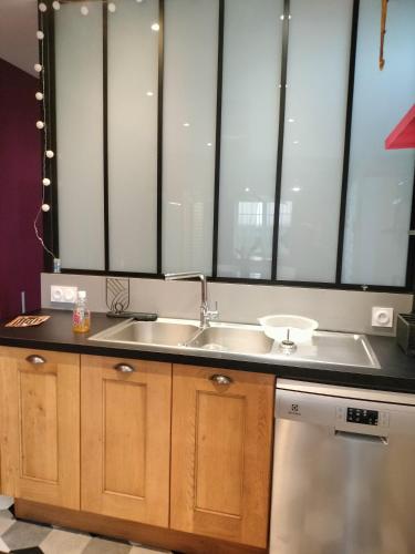 Il comprend une cuisine avec un évier et 2 grandes fenêtres. dans l'établissement GITE DE GROUPE - 14 PERSONNES, à Faye-d'Anjou