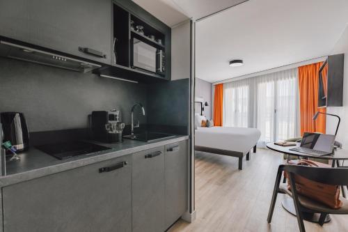 uma cozinha com um lavatório e uma mesa num quarto em Appart'City Collection Paris Gare de Lyon em Paris