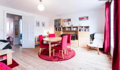 un salon avec une table et des chaises rouges dans l'établissement Duplex Lille-Centre, à Lille