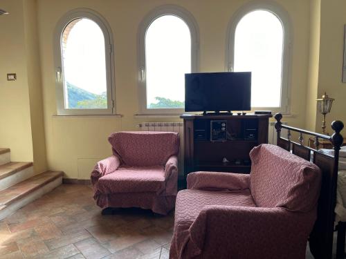 a living room with two chairs and a flat screen tv at Villa Felici in Giuliano di Roma