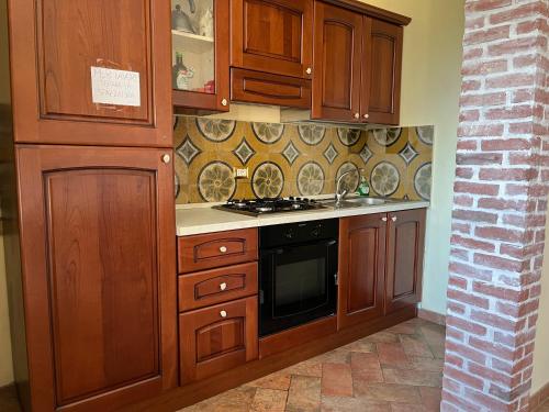 a kitchen with wooden cabinets and a stove at Villa Felici in Giuliano di Roma