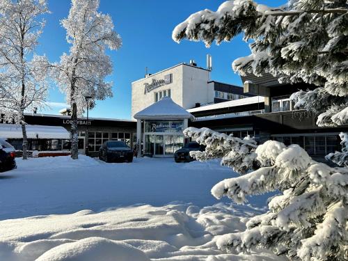 a parking lot covered in snow next to a building at Radisson Blu Resort, Beitostølen in Beitostøl
