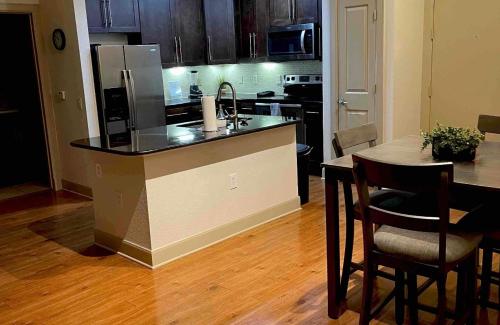 uma cozinha com um balcão e uma mesa com cadeiras em NRG Stadium - 2 Bedroom 2 Bath Apartment with Amenities em Houston