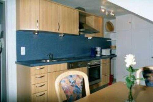 eine Küche mit Holzschränken und einer blauen Arbeitsplatte in der Unterkunft Haus am Hang Pension garni in Scharbeutz