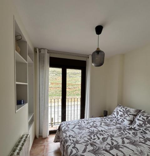 a bedroom with a bed and a door to a balcony at Casa Bambolia in Valdelinares