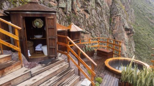 a wooden building with a bath tub and stairs at Starlodge Adventure Suites in Urubamba