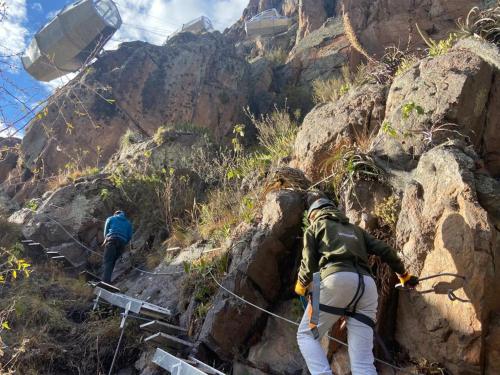 zwei Menschen, die mit einem Seil einen Berg hinauflaufen in der Unterkunft Starlodge Adventure Suites in Urubamba