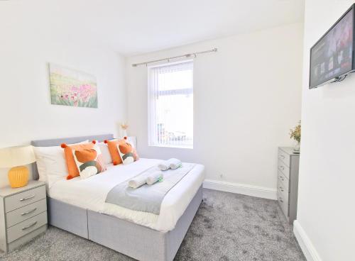 バーンリーにあるBurnley Terraced House by BEVOLVE - Free Parking 3のオレンジ色の枕が付いた大きなベッドのある寝室