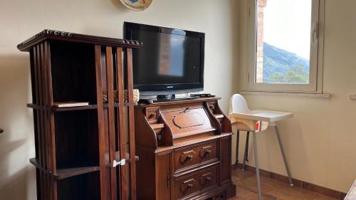 a tv sitting on top of a wooden entertainment center at Villa Felici in Giuliano di Roma