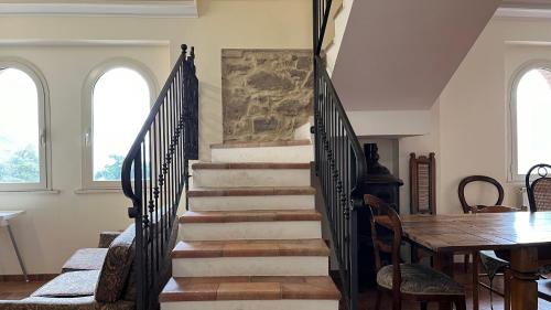 a staircase in a living room with a table and chairs at Villa Felici in Giuliano di Roma