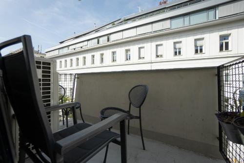 une chaise assise sur un balcon avec un bâtiment dans l'établissement Charming Apartment with Balcony, Close to Stephansdom Cathedral, à Vienne