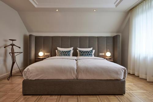 a bedroom with a large bed and two lamps at Parkhotel Gütersloh in Gütersloh