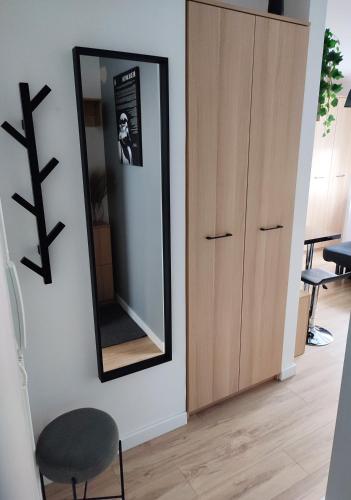 a mirror on a wall next to a chair at Apartamenty Urban Concept in Zamość