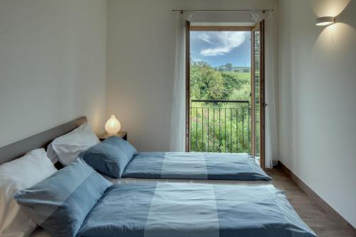 a bedroom with a bed with a large window at Tenuta di Palú in Bardolino