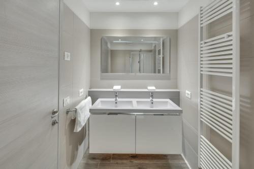 een witte badkamer met een wastafel en een spiegel bij Tenuta di Palú in Bardolino