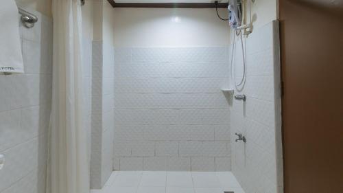 uma casa de banho com chuveiro e cortina de chuveiro em Garden Plaza Hotel Manila em Manila