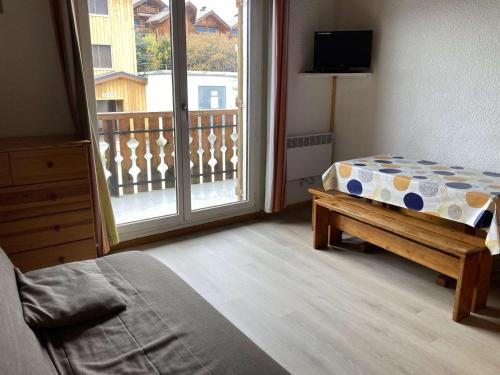une chambre avec un lit et une fenêtre avec un balcon dans l'établissement Studio 4 pers avec balcon, proche centre et pistes - L'Alpe d'Huez - FR-1-405-20, à L'Alpe-d'Huez