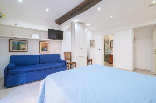 Un dormitorio con una cama azul y un sofá. en Fusari 4 by Studio Vita, en Bolonia