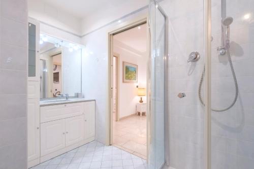 Un baño blanco con ducha y lavabo. en Fusari 4 by Studio Vita, en Bolonia